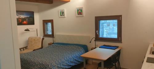 una camera da letto con un letto, un tavolo e una scrivania di Locanda delle fonti a Bassano in Teverina