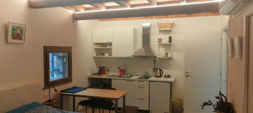 een keuken met witte kasten en een tafel in een kamer bij Locanda delle fonti in Bassano in Teverina