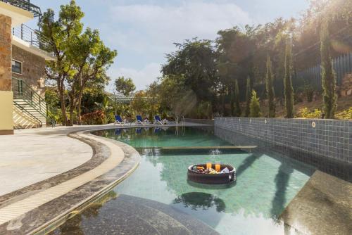 a small boat in a pool of water at SaffronStays Grand Pavilion in Udaipur