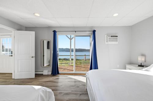 a white room with two beds and a window at Waterfront Walk Out with Private Terrace in Groton