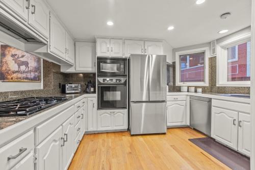 eine Küche mit weißen Schränken und einem Edelstahlkühlschrank in der Unterkunft MOTHERLODE 3 townhouse in Park City