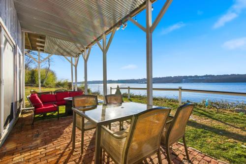 a table and chairs on a patio with a view of the water at Waterfront Walk Out with Private Terrace in Groton