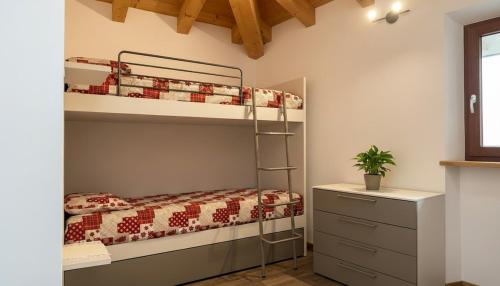 a bedroom with a bunk bed and a dresser at Paradiso di Grosio - mansarda con vista montagne in Grosio