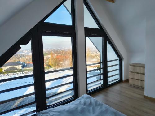 a bedroom with a large window with a view at Domki nad jeziorem in Dobczyce