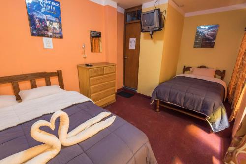 a room with two beds with a heart shaped towel at Hotel Galaxia in Huaraz