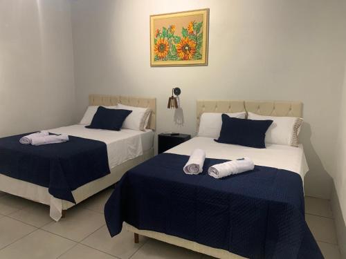 twee bedden in een kamer met blauw en wit bij 103-Quarto Pousada HG in Vila Nova do Sul