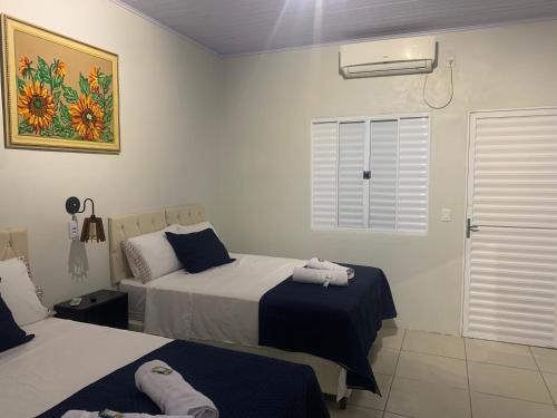 ein Hotelzimmer mit zwei Betten und einem Fenster in der Unterkunft 103-Quarto Pousada HG in Vila Nova do Sul