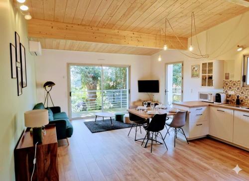 a kitchen and living room with a table and chairs at Cottage Les Ormeaux - à 13 minutes du Puy du Fou in Les Herbiers