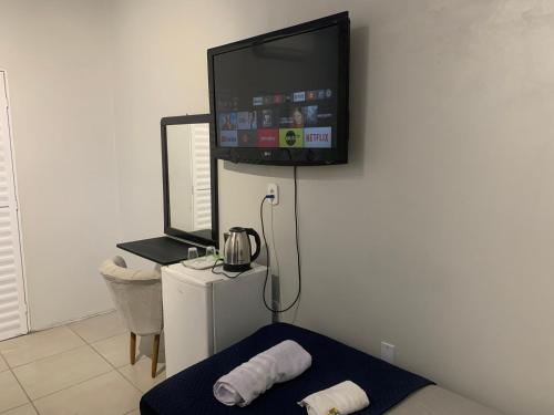 Zimmer mit einem TV an der Wand und einem Bett in der Unterkunft 103-Quarto Pousada HG in Vila Nova do Sul