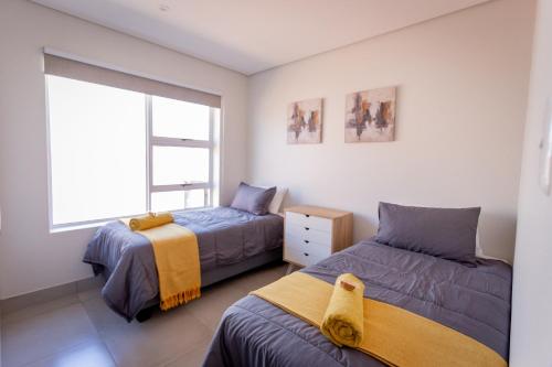 une chambre avec deux lits et une fenêtre dans l'établissement Modern 2 bed apartment - TH61, à George