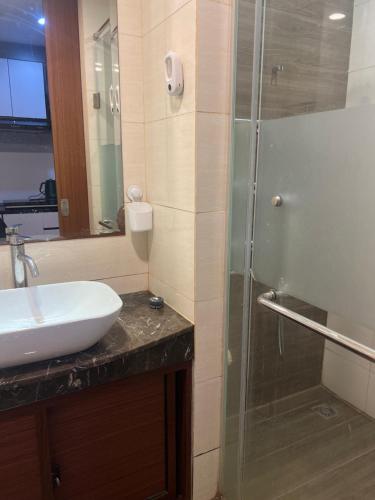 een badkamer met een wastafel en een glazen douche bij Fave apartment Nagoya Thamrin in Nagoya
