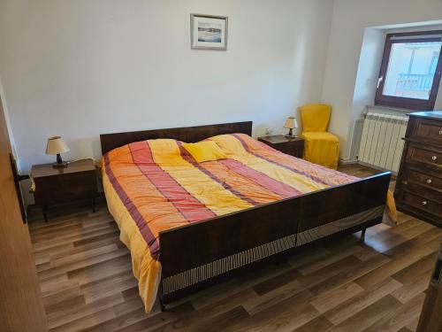 a bedroom with a bed and two tables and a chair at Kraska hisa in Komen