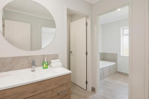 a bathroom with a white sink and a mirror at A million city views in Rotorua