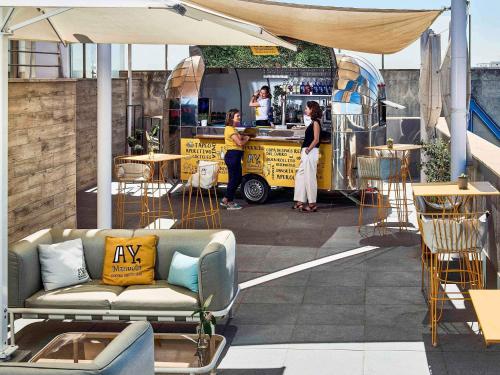 een food truck met mensen die ervoor staan bij Novotel Sevilla in Sevilla
