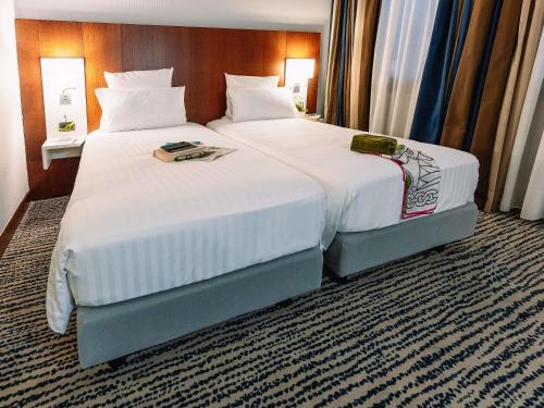 a hotel room with two beds with white sheets at Mercure Roma Piazza Bologna in Rome