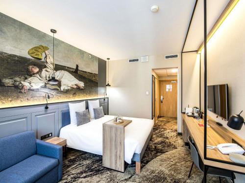 Mercure Wrocław Centrum في فروتسواف: غرفة فندق بسرير واريكة زرقاء