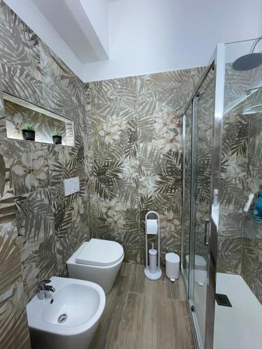 a bathroom with a toilet and a sink and a shower at Salinelle Home in Paterno