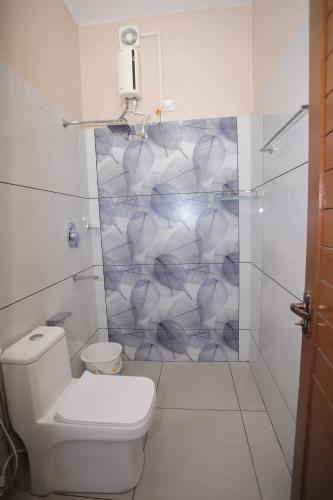 a white bathroom with a toilet and a shower at NALINAM HOMESTAY in Trivandrum