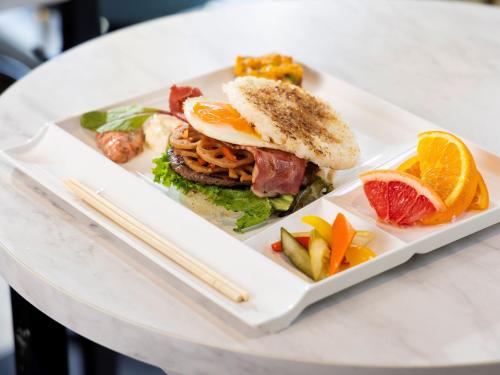 une assiette avec un sandwich et des fruits sur une table dans l'établissement Hotel Wing International Select Osaka Umeda, à Osaka
