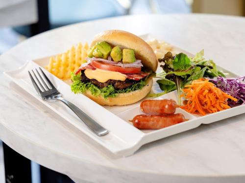 une assiette de nourriture avec un sandwich et du maïs sur une table dans l'établissement Hotel Wing International Select Osaka Umeda, à Osaka