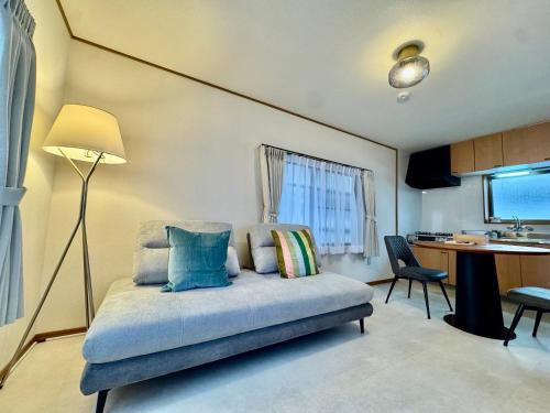 a bedroom with a bed with a desk and a table at VillaMonica Riverside in Nagoya