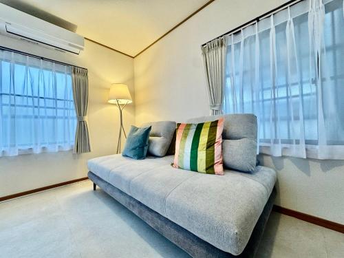 a living room with a couch with a pillow on it at VillaMonica Riverside in Nagoya