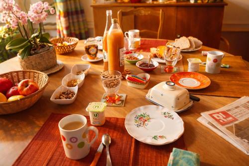 un tavolo di legno con tazze e piatti di cibo sopra di La Verrière du May a Sancy-le-Bas