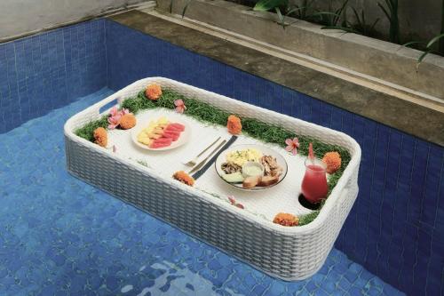 een model van een tafel met eten en drinken in een mand bij ME Villas Pererenan, Canggu in Canggu