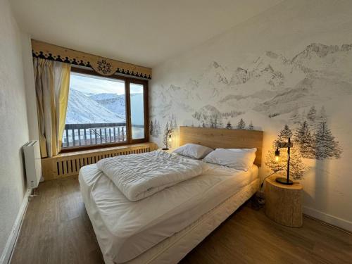 ein Schlafzimmer mit einem Bett mit einem Wandbild der Berge in der Unterkunft BEC452- Superbe 2 pièces, vue Lac - Tignes in Tignes