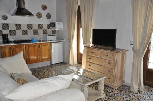 a living room with a couch and a tv on a dresser at Casa de las Remigias in Estepona