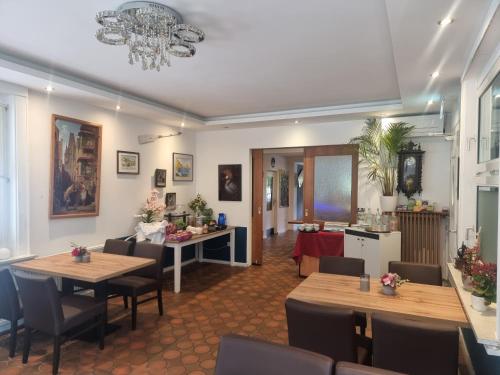 een woonkamer met tafels en stoelen en een keuken bij Hotel Silonce Radevormwald am See -ruhige Lage im Grünen, Parkplatz und Garten ideal für Natur und Wanderfans in Radevormwald