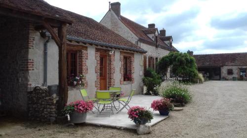 eine Terrasse eines Hauses mit Stühlen und Blumen in der Unterkunft Chambre "La Volière", Champliveau in Bonnée