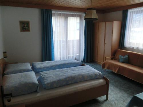 sypialnia z 2 łóżkami i kanapą w obiekcie Haus Pranger w mieście Gschnitz