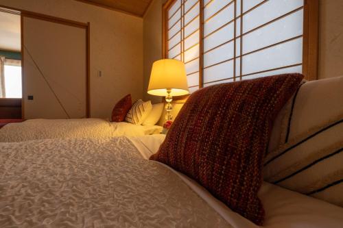 En eller flere senge i et værelse på HAKUBA Premium Ski Base - Private Onsen Villa