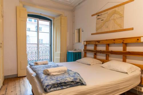 een slaapkamer met twee bedden en een balkon bij WOT New Lisbon Social in Lissabon