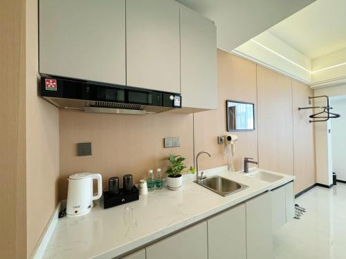 una cucina con mobili bianchi e un lavandino di Four Seasons Hotel a Vientiane