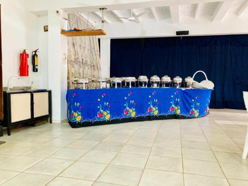 een blauwe tafel met potten erop in een kamer bij New Verona Hotel in Wennappuwa