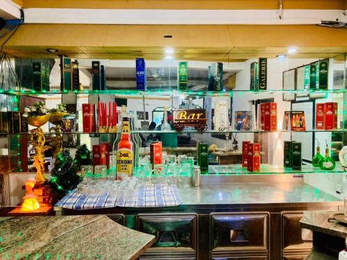 a bar with a lot of alcohol bottles and glasses at New Verona Hotel in Wennappuwa
