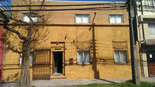 a yellow house with windows and a door at Hotel con C in Concepción