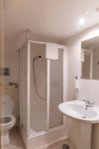 a bathroom with a shower and a sink and a toilet at WOT New Lisbon Social in Lisbon