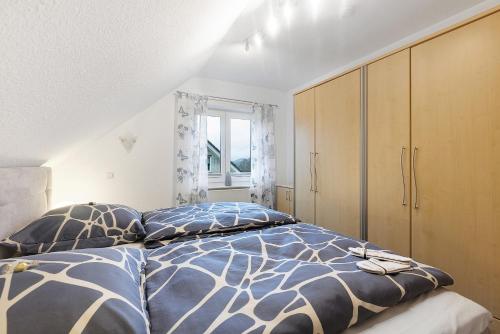 een slaapkamer met een bed met kussens en een raam bij Ferienwohnung Westfeld in Bestwig