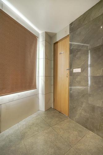 a bathroom with a shower with a wooden door at Hotel Global Inn - Few steps walk to Golden Temple in Amritsar