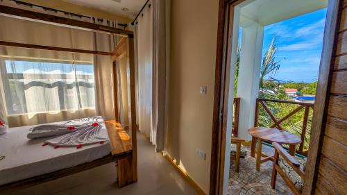 a bedroom with a bed and a view of a balcony at Joujo's Jungle Guest House in Nungwi