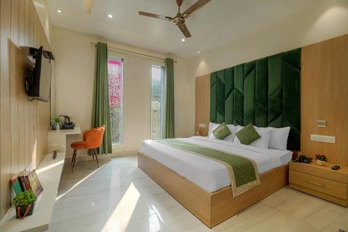 ein Schlafzimmer mit einem großen Bett mit grünem Kopfteil in der Unterkunft Hotel Global Inn in Amritsar