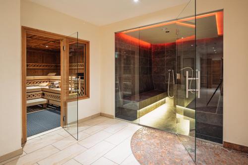 een badkamer met een douche en een glazen douchecabine bij Hotel Garni Alpenjuwel in Serfaus