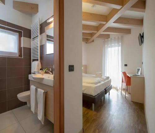 een badkamer met een bed en een wastafel in een kamer bij Cameras Mori in Mori