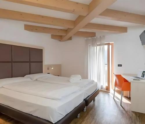 een slaapkamer met een groot bed en een bureau bij Cameras Mori in Mori