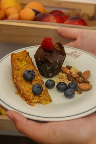 una persona che tiene un piatto con del cibo sopra di Hotel Lory My Wellness SPA a Chianciano Terme