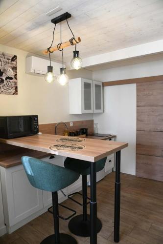 a kitchen with a table and a blue chair at Confortable studio avec jardin in Saint-Doulchard