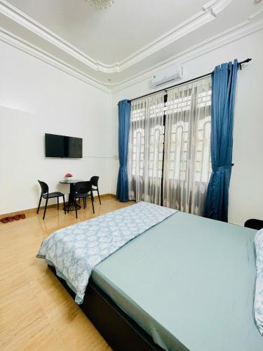 a bedroom with a bed and a table with chairs at SAM HOUSE 2 Huế in Cồn Giả Viên
